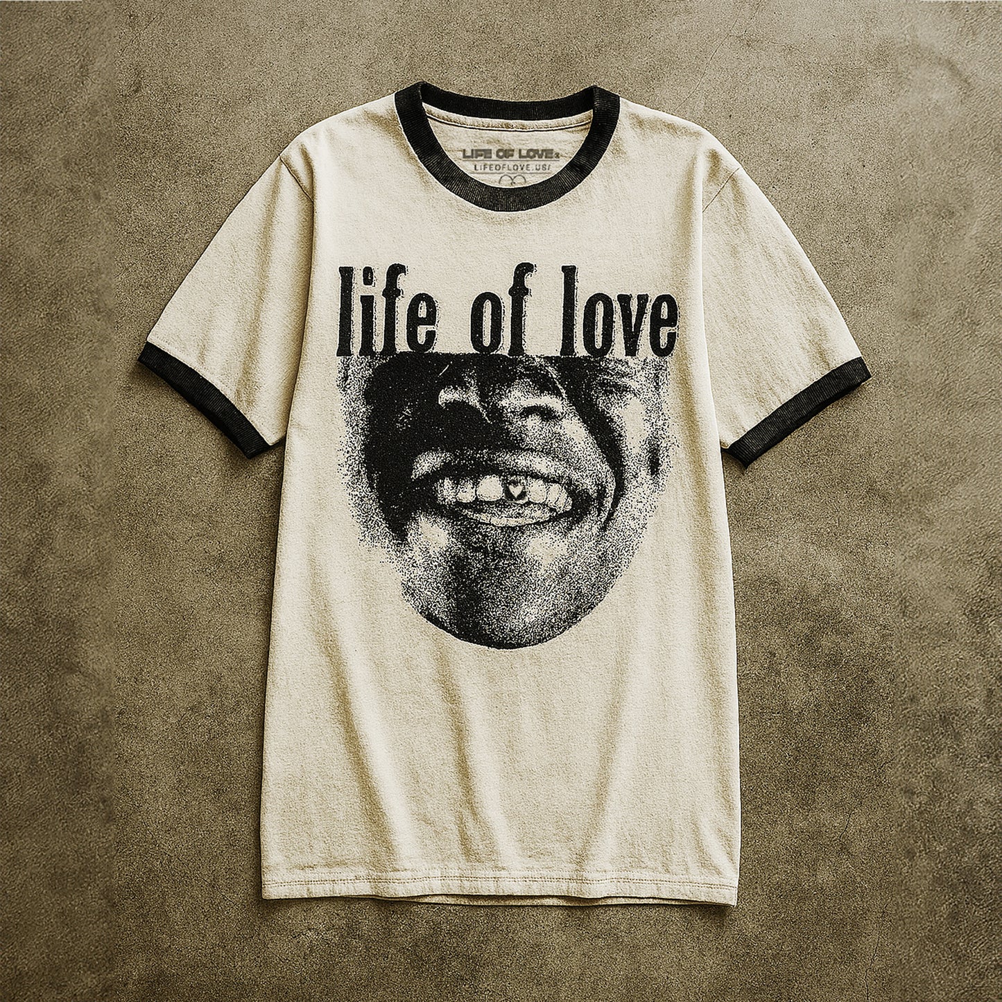 White t-shirt with black text 'life of love' and a graphic on a textured brown background