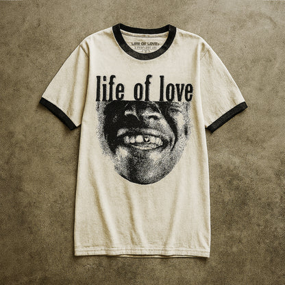 White t-shirt with black text 'life of love' and a graphic on a textured brown background
